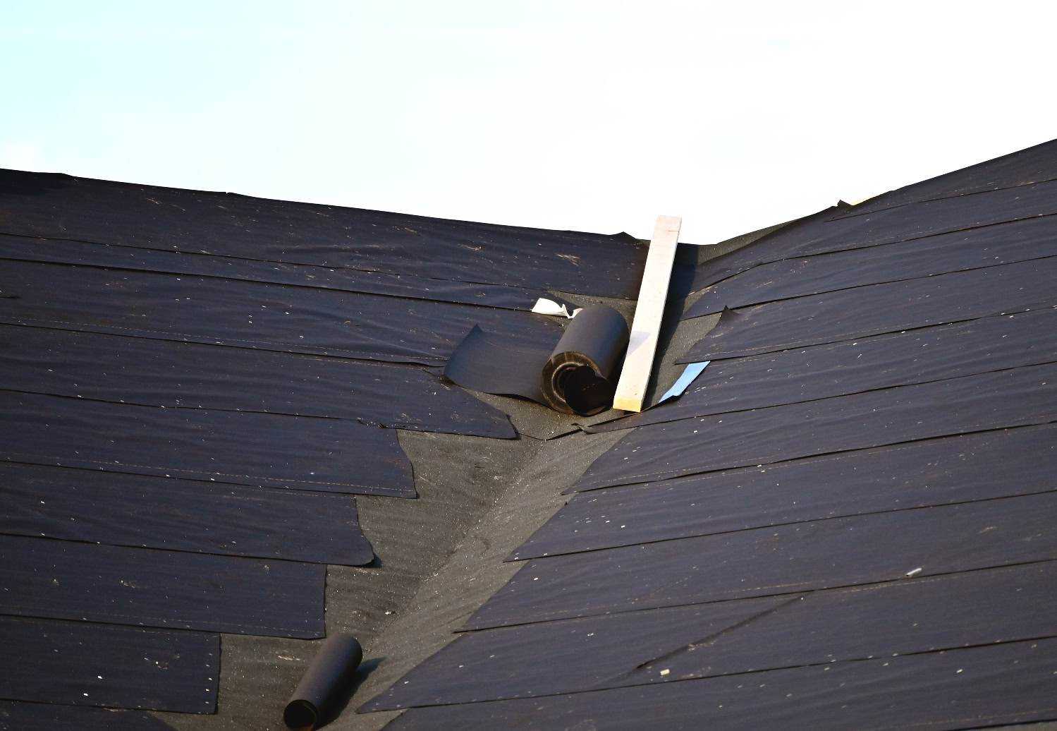 Close-up of roof decking and shingle layers during professional inspection